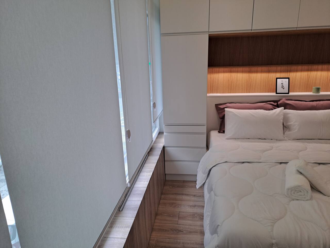 Bedroom side view with built-in storage and ambient lighting