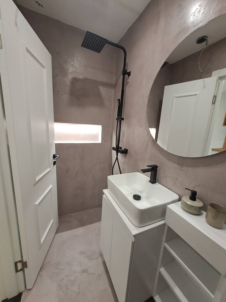 Modern bathroom with rainfall shower and concrete finish
